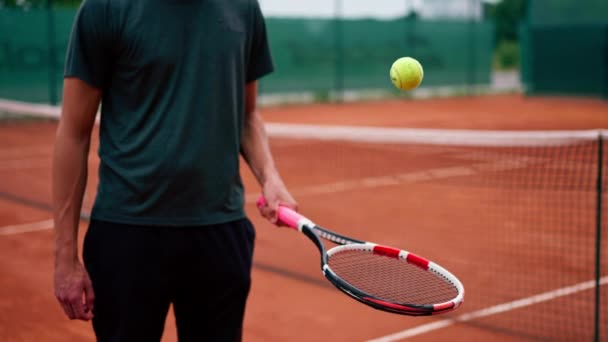 lähikuva nuori tennispelaaja kouluttaja lyömällä pallo maila tenniskenttä valmistautuu kilpailuun urheilu elämäntapa - Materiaali, video