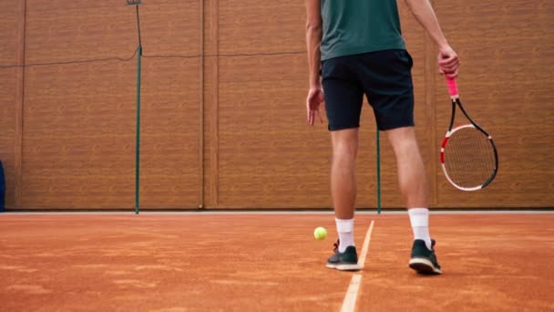 Açık hava tenis kortunda profesyonel oyuncu koçu raket tenis topuyla vuruşlar yapıyor. - Video, Çekim
