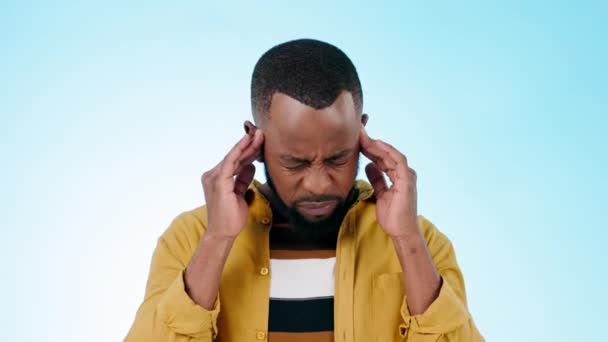 Zwarte man, hoofdpijn en massage tempel met stress of burn-out in de studio met pijn op blauwe achtergrond. Migraine, spanning en hersenmist met mockupruimte, pijn en levenscrisis met duizeligheid en vermoeidheid. - Video