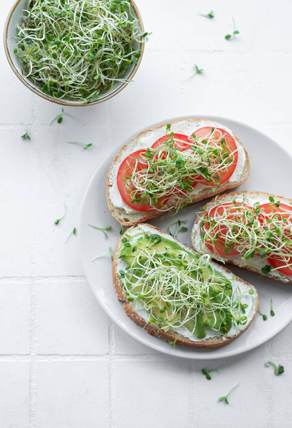 Alimentación Saludable. Sandwiches con tomates, aguacate y microgreens frescos. - Foto, imagen