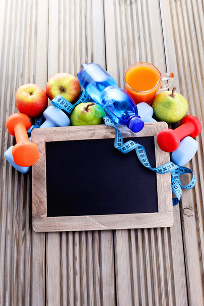 Fitness frame with dumbbells and fruits - Foto, afbeelding