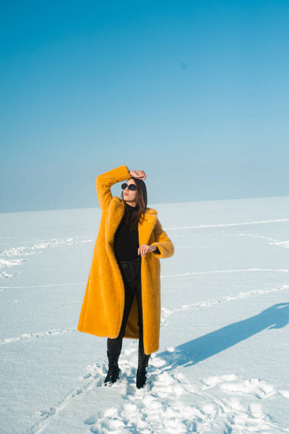 женщина в желтом пальто весело на снежном льду, свобода концепции - Фото, изображение
