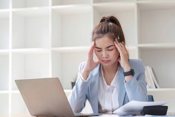 Kafası karışmış Asyalı kadın bilgisayar ekranına bakarak problemleri nasıl çözeceğini çok düşünüyor. Ciddi Asyalı iş kadını ofiste zor bilgisayarları çözmeye odaklanmış.. - Fotoğraf, Görsel