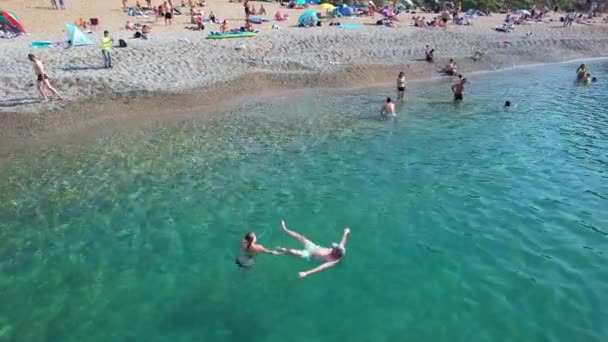 Люди наслаждаются жаркой британской погодой на лодках и плывут по океанскому пляжу с видом на море. Запись сделана 9 сентября 2023 года - Кадры, видео