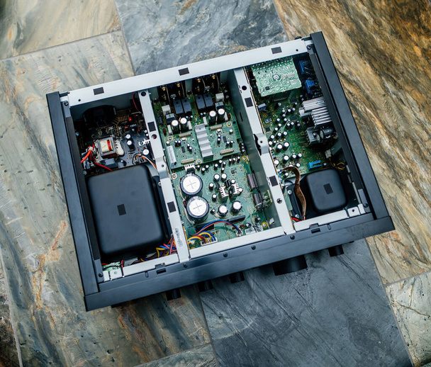 La tapa metálica abierta de un nuevo amplificador Hi-Fi Clase D revela una compleja gama de componentes internos. - Foto, Imagen