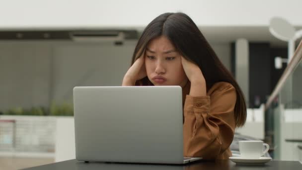 Estresado mujer asiática cansada trabajadora de oficina mujer de negocios coreana china chica japonesa freelance trabajando en línea con ordenador portátil en café estrés negocio fracaso proyecto error en el sitio web - Metraje, vídeo