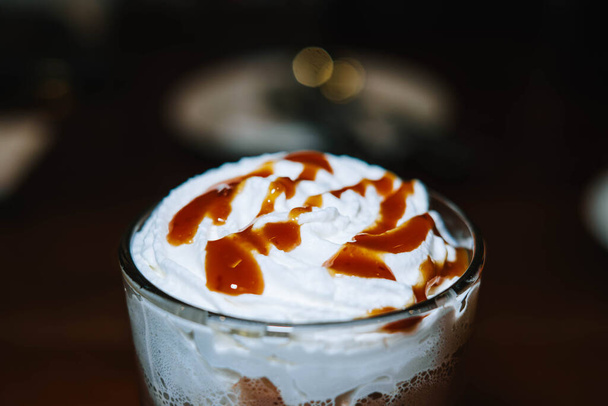 Chocolate com Creme Chicoteado e Molho de Caramelo em um copo com fundo bokeh - Foto, Imagem