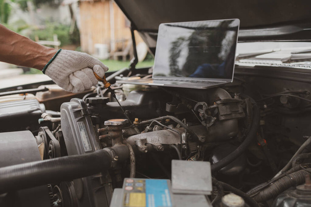 Car mechanic is inspecting the engine of a car coming in for repair at the center. Professional engine specialist, car repair, car breakdown. Car maintenance and repair concept. - Photo, Image