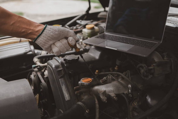 Auto monteur inspecteert de motor van een auto die in het centrum komt voor reparatie. Professionele motor specialist, auto reparatie, auto-uitval. Auto-onderhoud en reparatie concept. - Foto, afbeelding