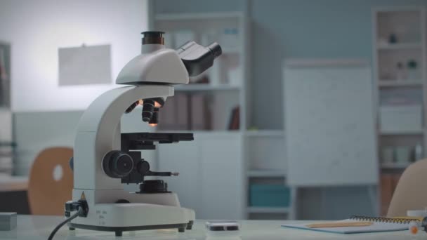 Nessun colpo della gente del microscopio moderno sulla tavola nel laboratorio scientifico bianco moderno - Filmati, video