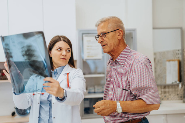 Lékař a pacient Prohlížení rentgenových výsledků v nemocniční klinice - Fotografie, Obrázek