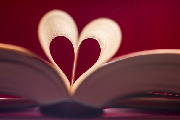 Blurry heart made from book pages over red background. Valentines theme. - Photo, Image
