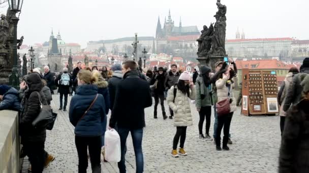 Ihmiset kävelemässä Kaarlen sillalla - kaupunki - Prahan linna taustalla - pilvinen
 - Materiaali, video