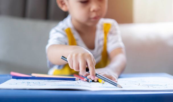 Enfoque selectivo de bebé niño manos detalle de un niño pequeño para colorear dibujo con lápices multicolores. Concepto de aprendizaje infantil. - Foto, Imagen