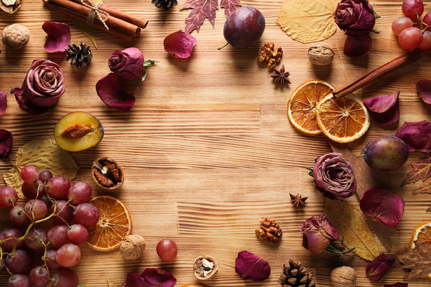 Uvas, capullos de rosa y frutos secos sobre fondo de madera, espacio para texto - Foto, imagen