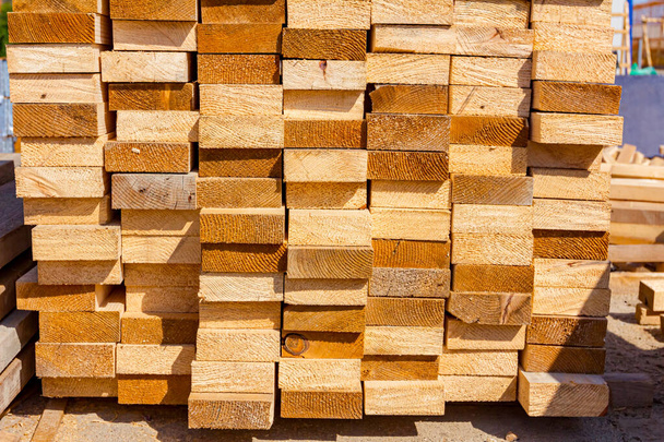 Yellow wooden chopped planks arranged in a row placed at the alfresco on the construction site. - Photo, Image