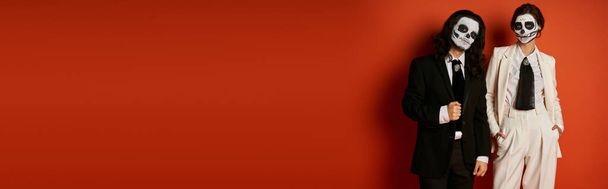 módní pár v dia de los muertos cukr lebky make-up a obleky při pohledu na kameru na červenou, banner - Fotografie, Obrázek