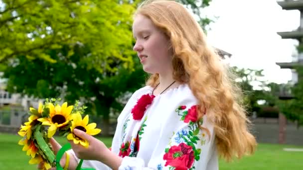 piękna rudowłosa ukraińska dziewczyna w haftowanej bluzce kwiaty czerwone maki na białej koszuli słoneczniki wieniec w jej wstążki włosy natura częstotliwość dziewicza piękno siła. Pokój radości zwycięstwa - Materiał filmowy, wideo