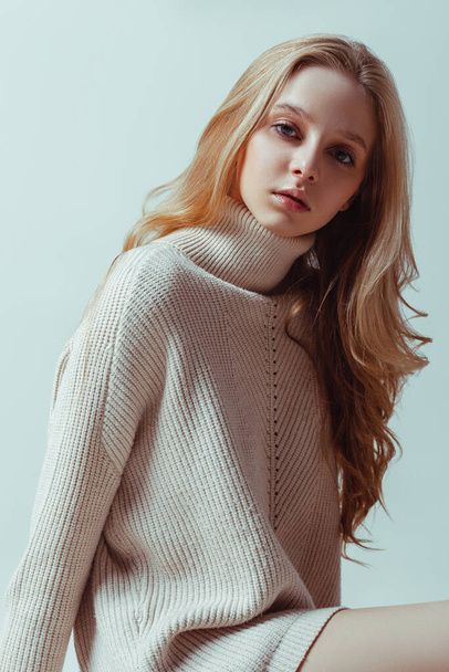 Young blonde caucasian girl in cozy sweater. Studio shot of good-looking beautiful woman. Oversized fitting sweatshirt style - Photo, Image