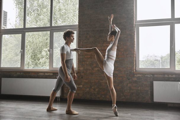 Современные артисты балета пара, исполняющая грациозную хореографию в классе художественной школы - Фото, изображение