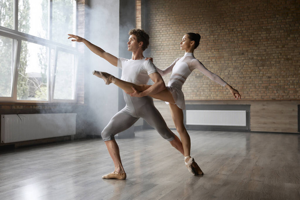 Graceful klasyczny duet baletowy występujący w pomieszczeniach. Tancerze choreografii współczesnej w akcji - Zdjęcie, obraz