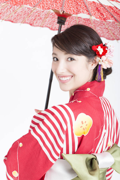 Porträt der schönen Japanerin im Kimono mit rotem Regenschirm  - Foto, Bild