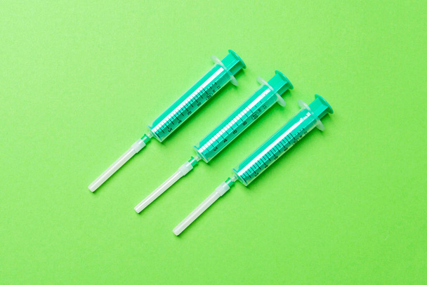 Top view of syringes in a row for medical injection on colorful background with copy space. Health and vaccination concept. - Photo, Image