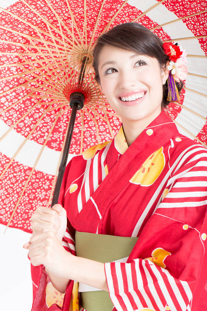portrait of beautiful japanese woman in kimono with red umbrella  - Photo, image