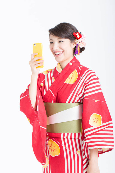 portrait of asian woman wearing kimono using smartphone - Foto, immagini
