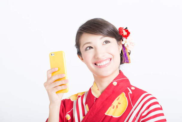 portrait of a beautiful young woman in traditional dress with a smartphone - Photo, image