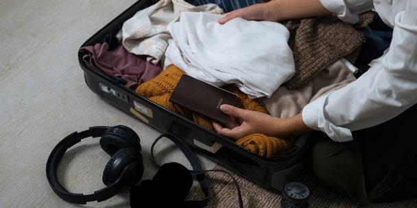 Close up młoda azjatycka kobieta podróżnik opakowanie torby przygotować się do podróży wakacje sezon, koncepcja podróży styl życia aktywna podróż i podróż, paszport. - Zdjęcie, obraz