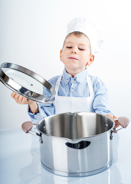 Mały chłopiec ubrany jak kucharz Dokonywanie diner - Zdjęcie, obraz