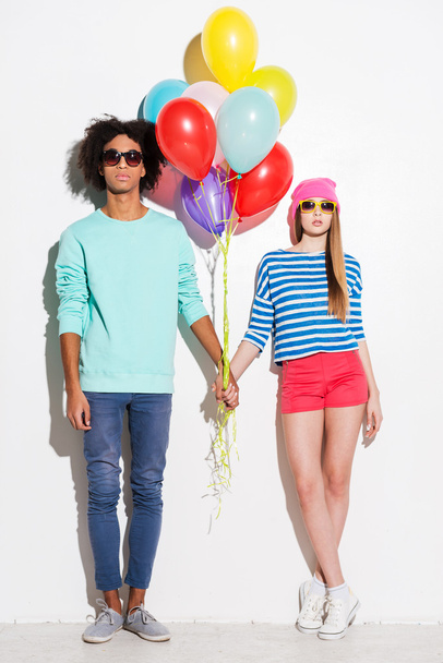 Funky young couple holding balloons - Фото, изображение
