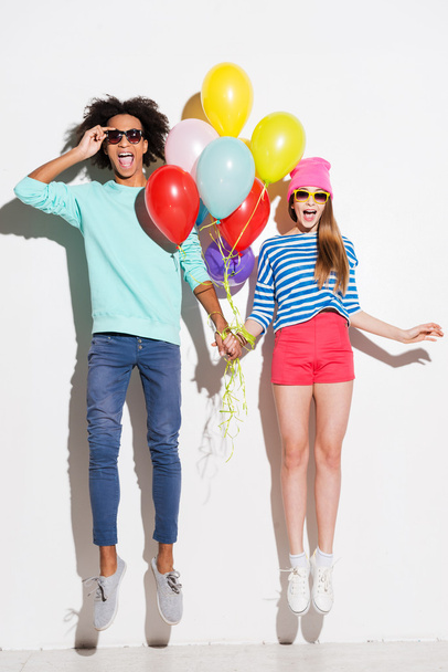 Funky young couple holding balloons - Фото, зображення