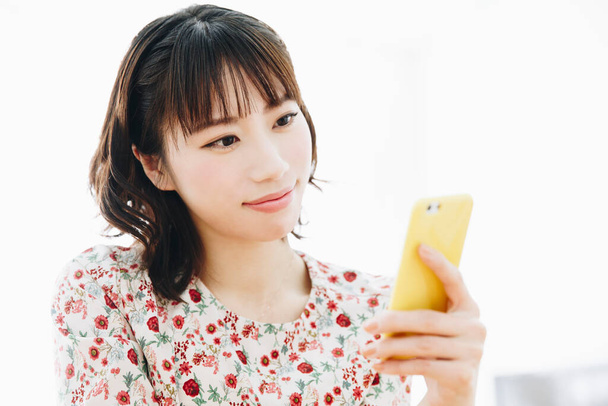 portrait of smiling young Asian woman using smartphone  - Фото, зображення