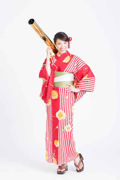 portrait of beautiful woman wearing japanese traditional costume holding telescope - Foto, afbeelding