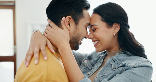 Couple, forehead touch and hug in living room with love, bonding and happy people together at home. Healthy relationship, trust and support in commitment, partner and dancing, romance and intimacy. - Photo, image