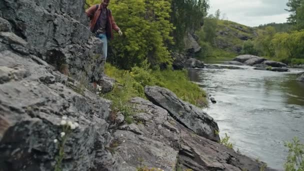 Нахилений знімок молодого чоловіка Біраціанський турист, що йде по краю скелі і зникає зі сцени - Кадри, відео