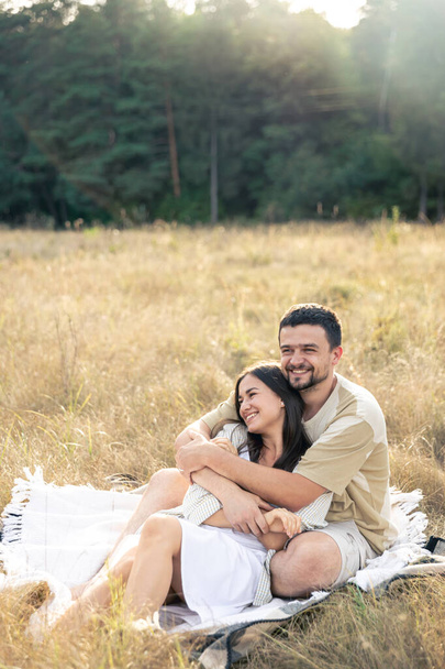 Happy married man and woman on a date relaxing in a field in summer, quality time together, close relationship, romance in marriage. - Photo, Image