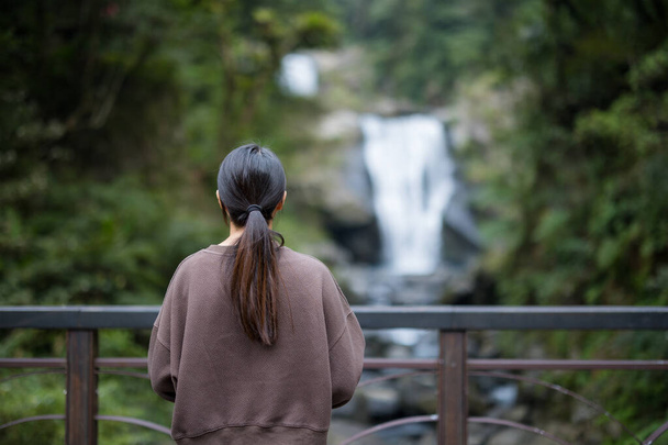 Blick der Frau auf den schönen Wasserfall - Foto, Bild