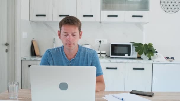 Jeune homme joyeux heureux avec son travail mettre les mains sous la tête tout en finissant de travailler sur un ordinateur portable en ligne à la maison et d'avoir une pause. Satisfait freelance masculin utilisant l'ordinateur pour le travail à distance jouissant de loisirs - Séquence, vidéo