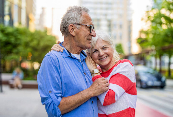 Ritratto di una felice coppia di anziani che si abbraccia in città - Foto, immagini