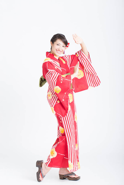 portrait of beautiful young woman wearing traditional japanese kimono posing isolated on white background  - Foto, Bild