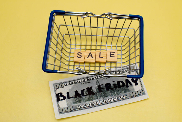 Black Friday Sale Shopping-Konzept. Warenkorb mit Dollarscheinen - Foto, Bild