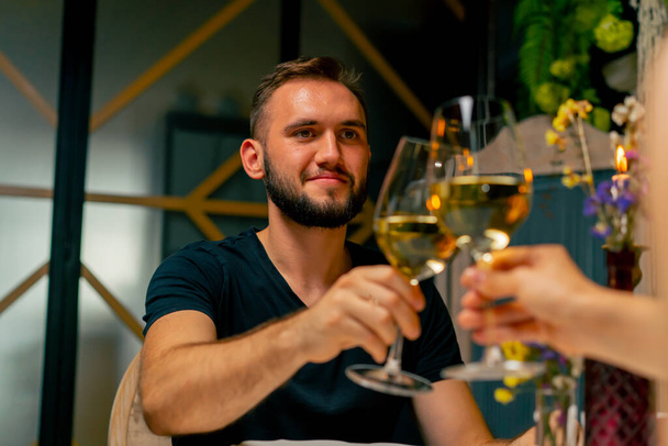 Mladý pár chlap a dívka sedí v italské restauraci sladce chatování a pití vína, zatímco na rande - Fotografie, Obrázek