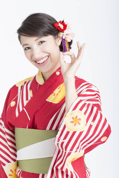 mujer joven vistiendo ropa tradicional japonesa mostrando signo de ok - Foto, imagen