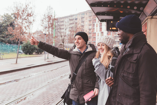 tres personas jóvenes amigos multiétnicos pidiendo taxi - viajero, autoestopista, concepto de coche compartido - Foto, Imagen