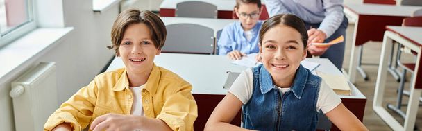 grupo feliz de estudantes em uma mesa em uma sala de aula brilhante e movimentada. - Foto, Imagem