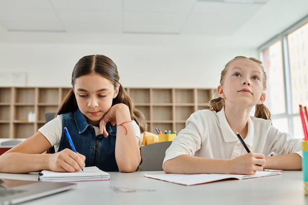 Two young girls actively participating in a classroom - Photo, Image