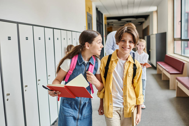 Un par de niños caminando enérgicamente por el pasillo, sus rostros llenos de emoción y curiosidad mientras exploran el ambiente escolar. - Foto, imagen